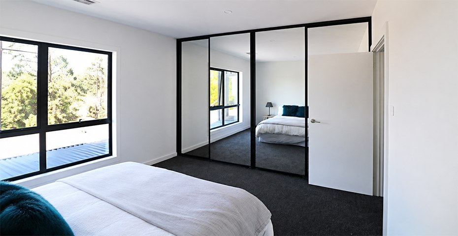 Custom mirrored sliding wardrobe doors installed in a Canberra bedroom by Monaro Screens