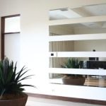 Custom-cut frameless wall mirror brightening a Canberra living room